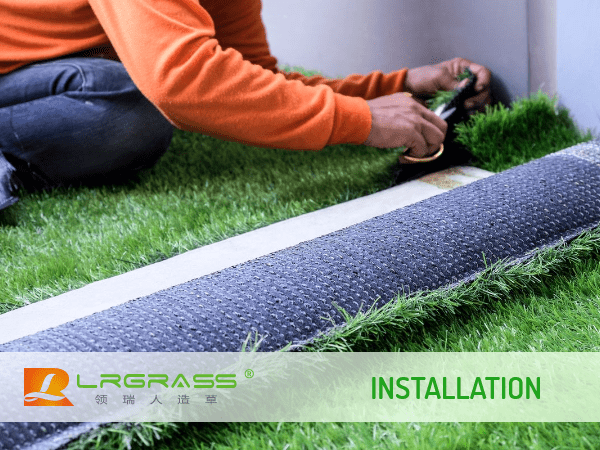 The worker is cutting the artificial grass into desired size.