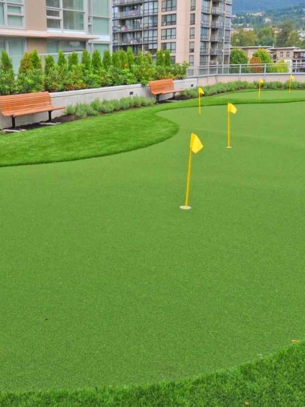Yellow flags are inserted in artificial grass putting green.