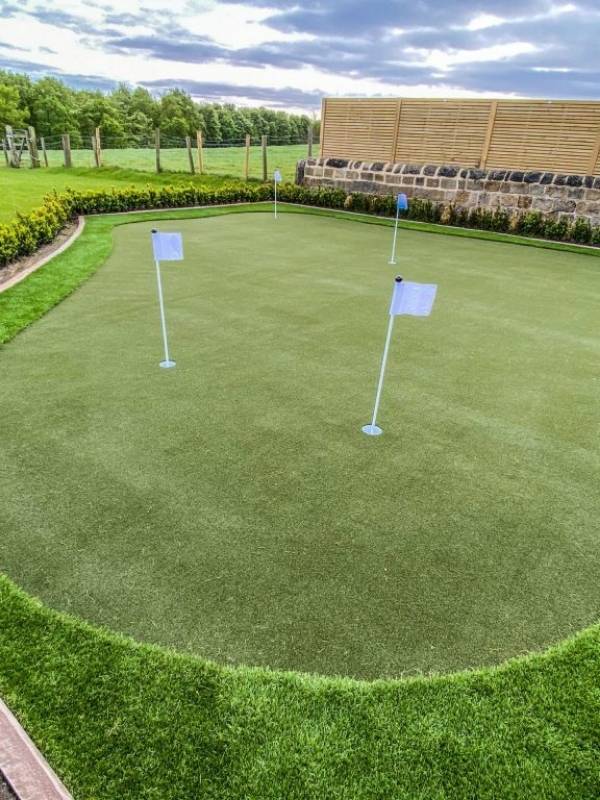 White flags are inserted in artificial grass putting green.