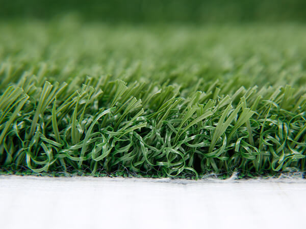 A piece of environmentally friendly artificial grass with dark green fibers