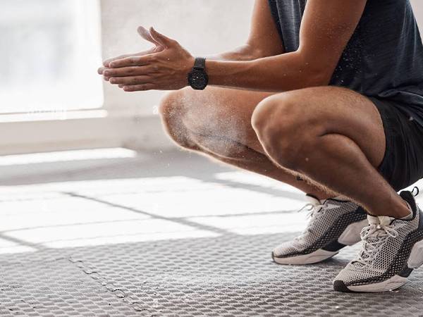 A man is doing exercise on interlocking sports flooring tiles.