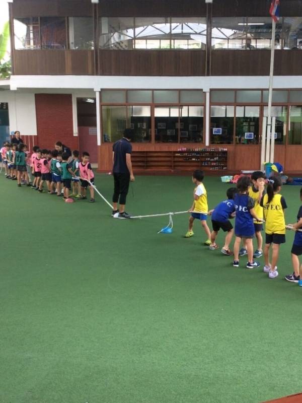 Many kids are playing games on kindergarten artificial turf