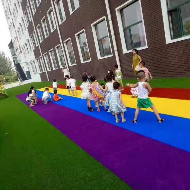 Several kids are playing on artificial turf.