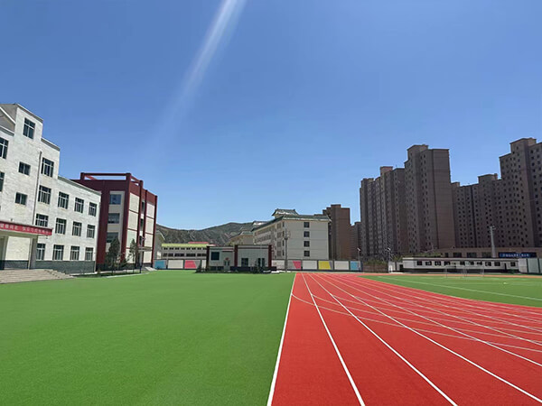 Terrain de football en gazon synthétique et piste de course dans une école