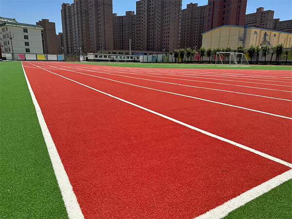 Artificial grass running track in front of tall buildings