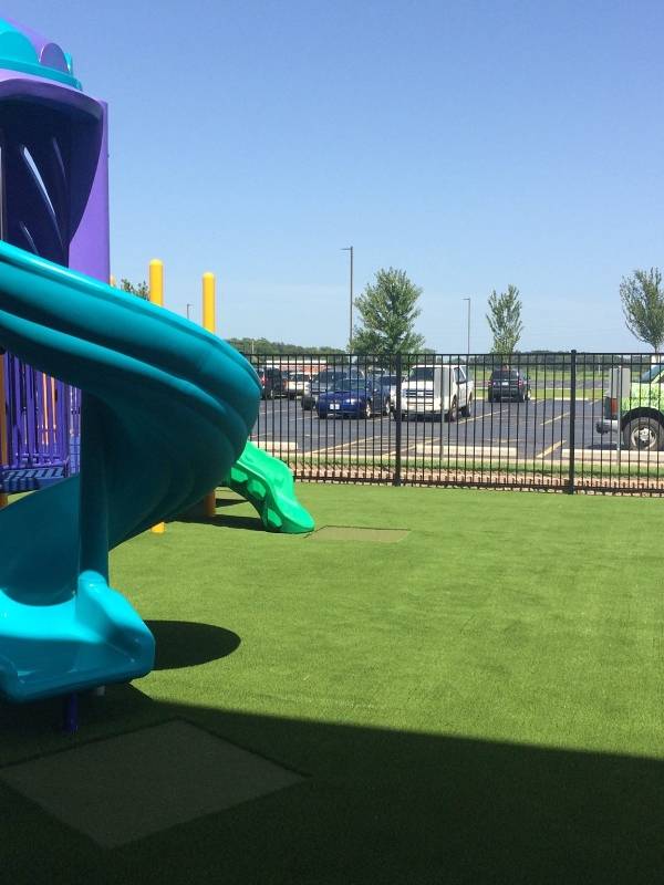 Playground artificial turf with a large slide