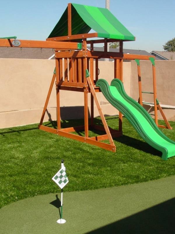 Playground artificial turf with a small slide
