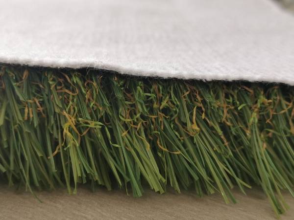 A triple-layer backing structure is sewn on recycled artificial grass plastic fibers.