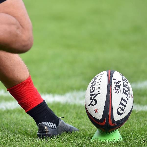 Spieler führen Rugby-Match auf Kunstrasen durch.